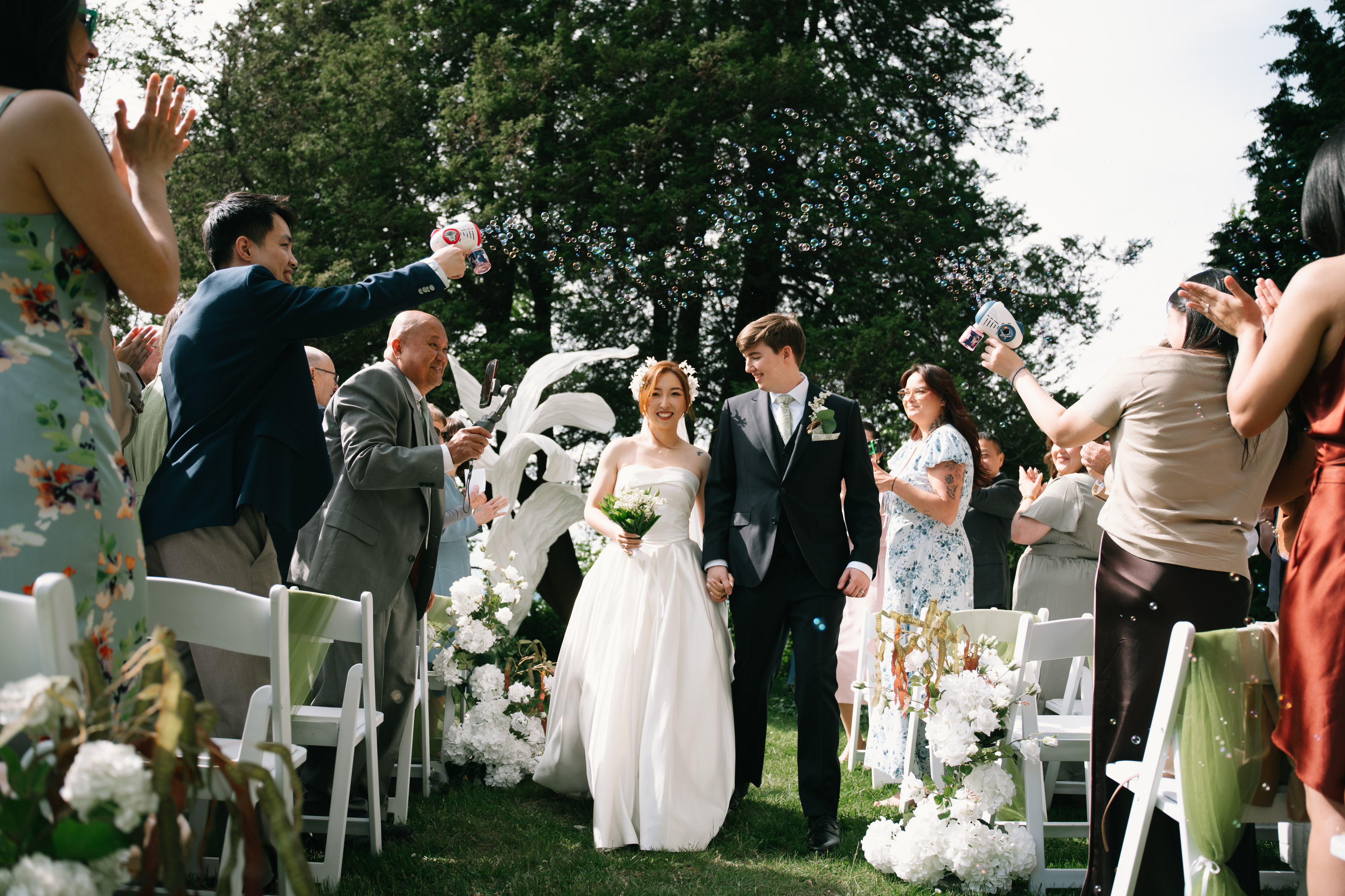 Newlyweds and guests celebrating in the garden at Cecil Green Park House