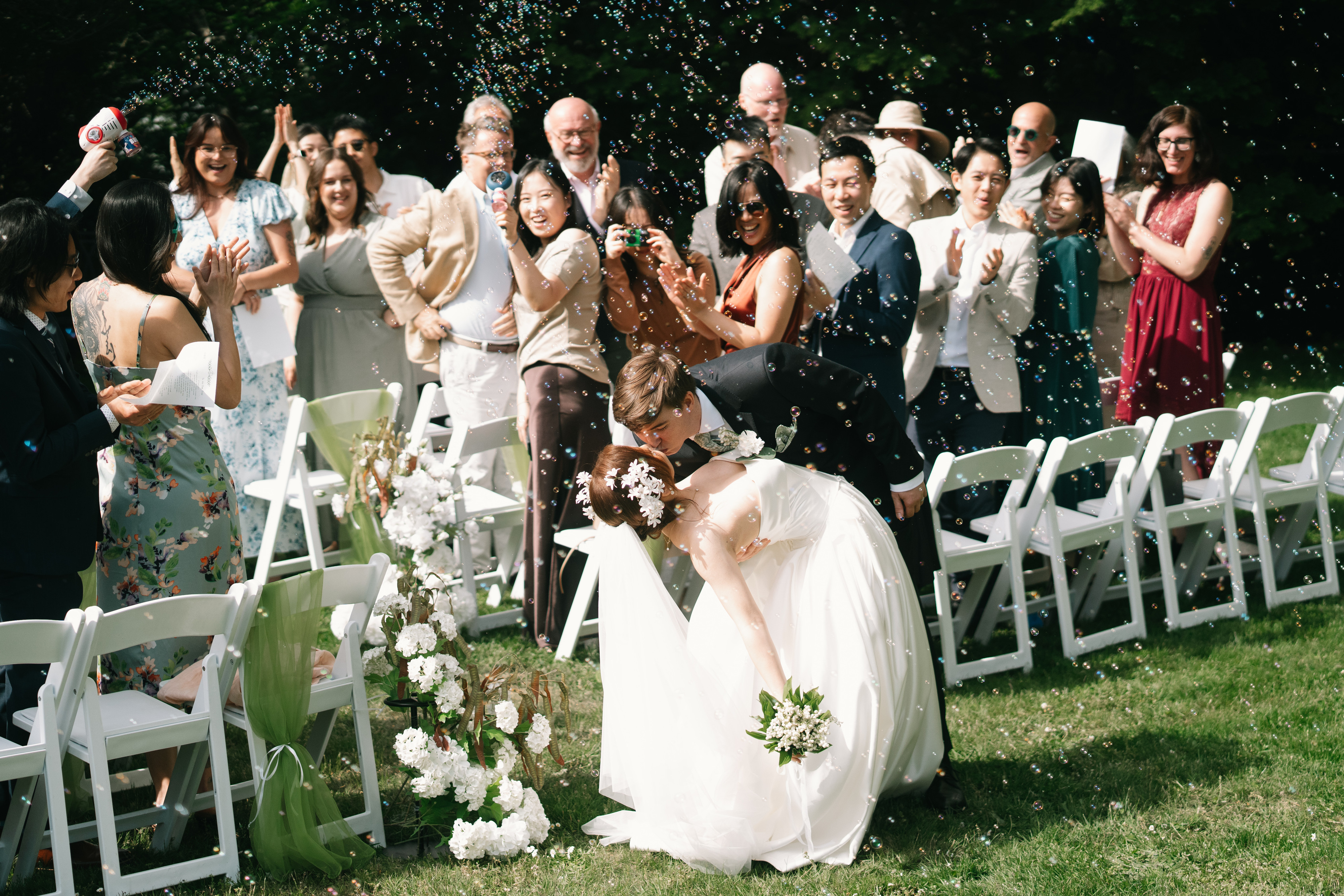Wedding guests celebrating around the newlyweds in a garden