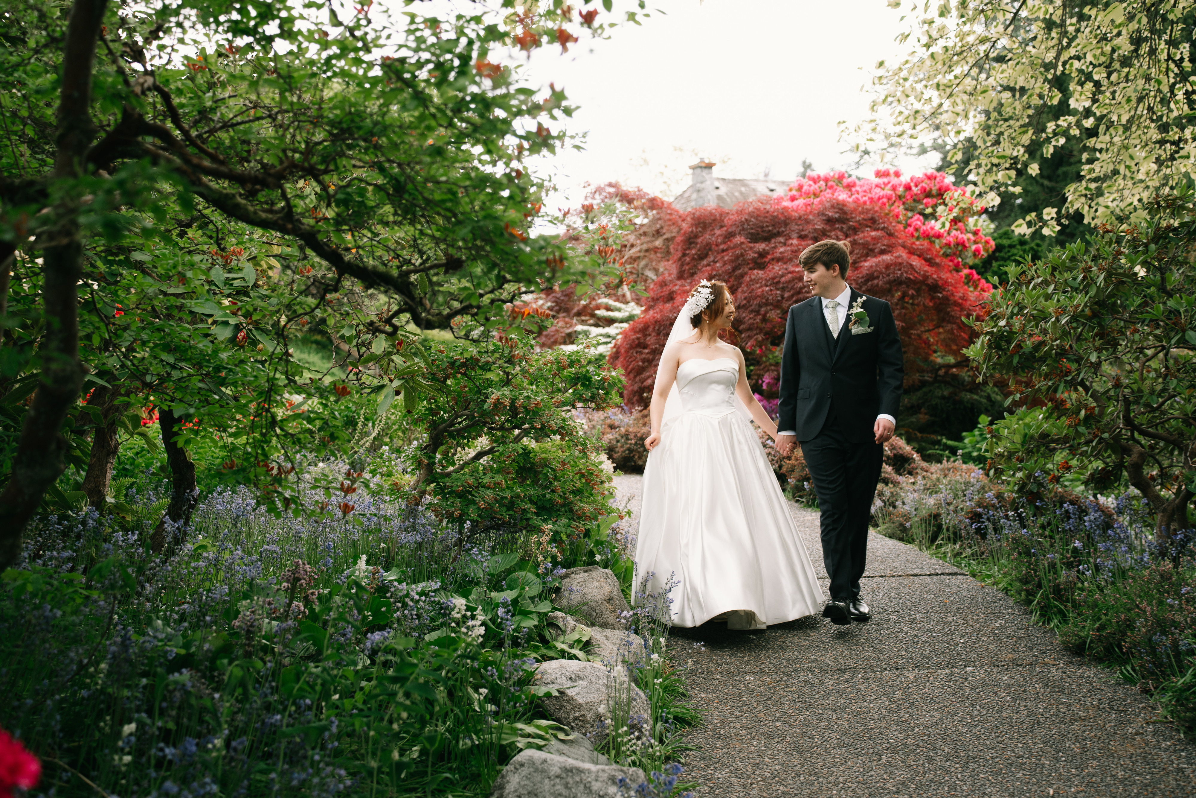 A couple walking hand in hand through the garden at Cecil Green Park House