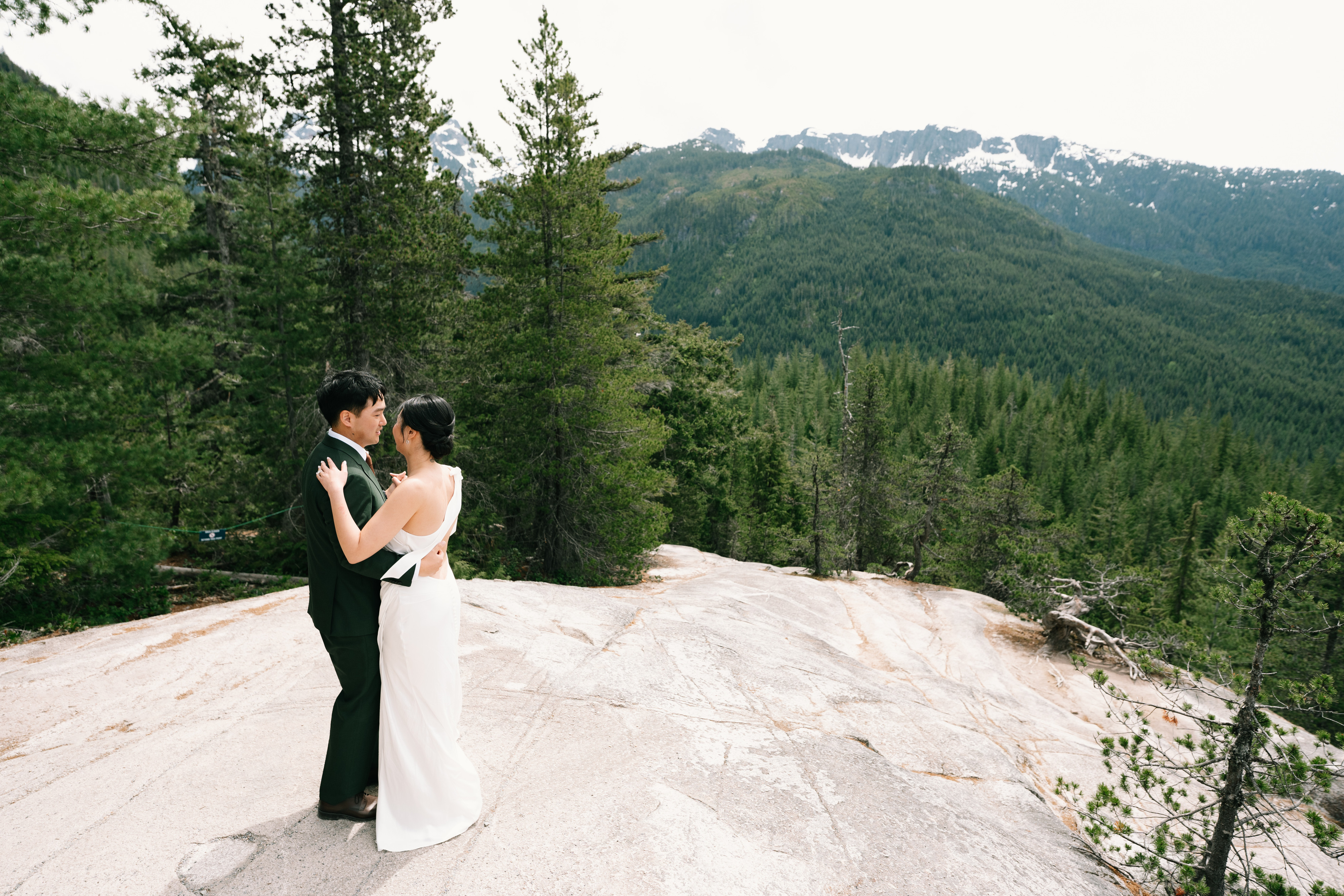Newlyweds embracing on a rocky mountain overlook