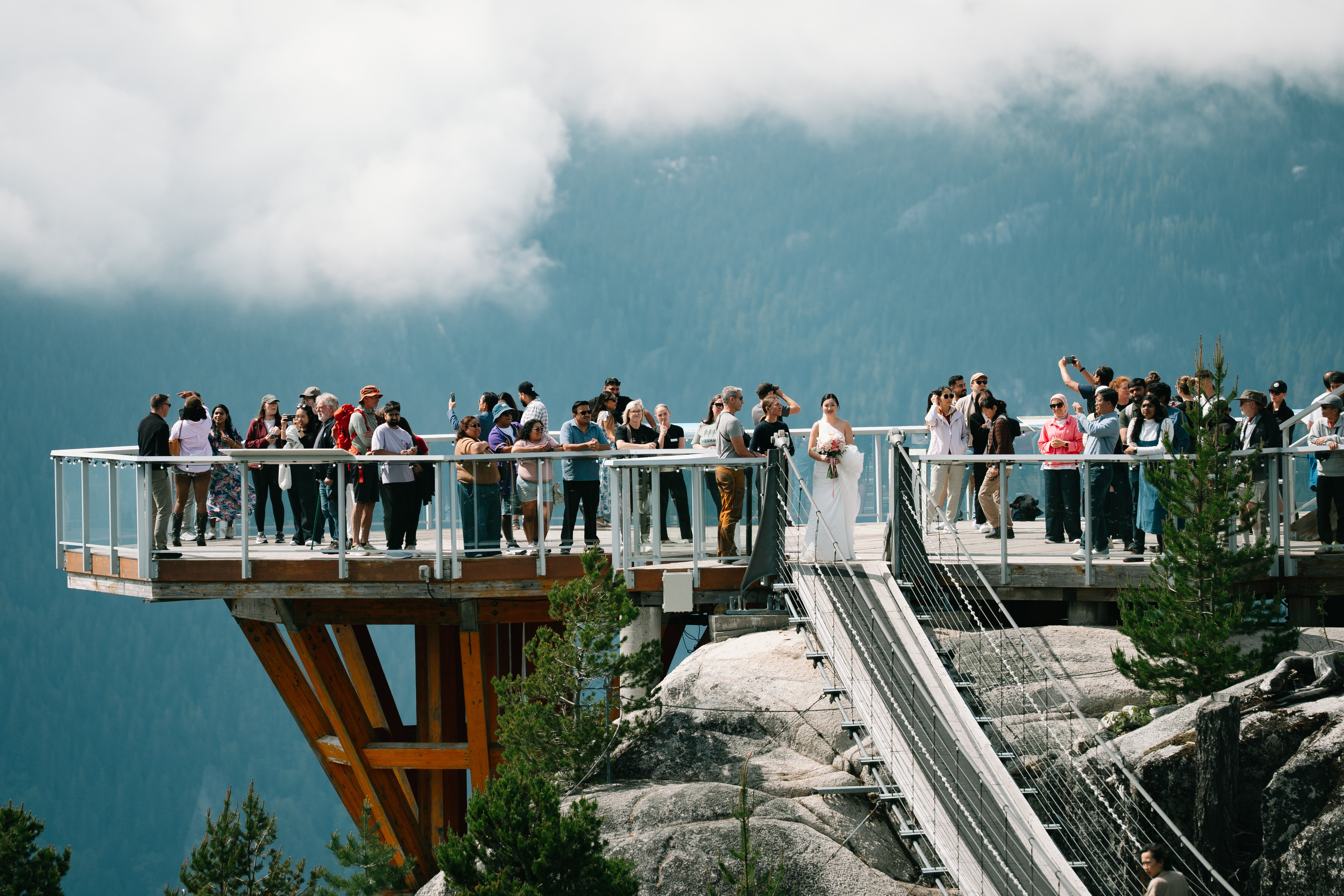 A bride and wedding guests on the mountain viewing platform at Sea to Sky Gondola